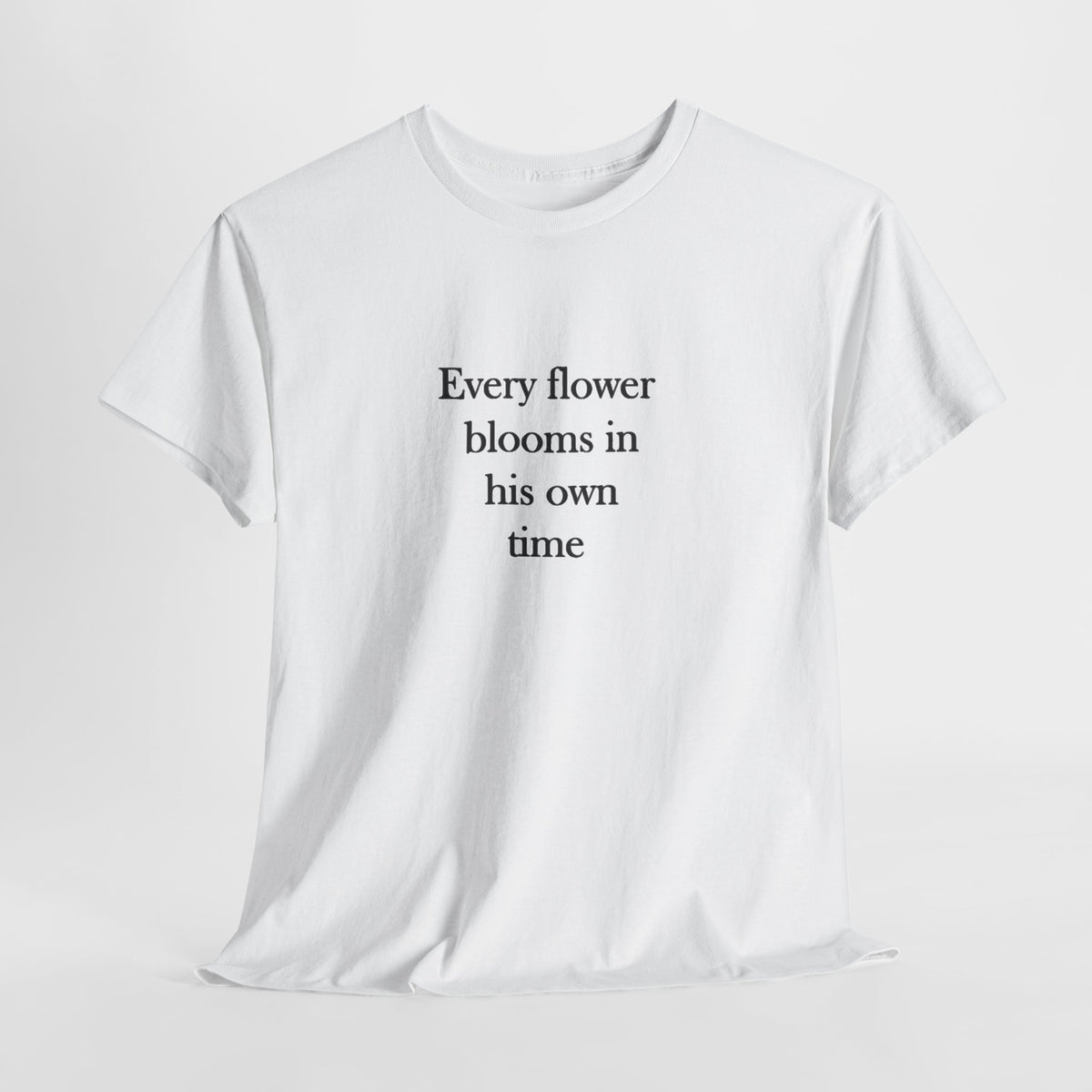Quote t-shirt reading 'Every flower blooms in his own time' in serif text